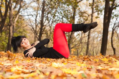 güzel bir kadın yoga egzersizleri sonbahar Park yapıyor