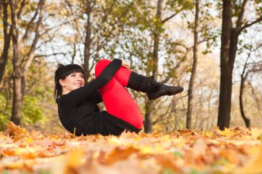 güzel bir kadın yoga egzersizleri sonbahar Park yapıyor