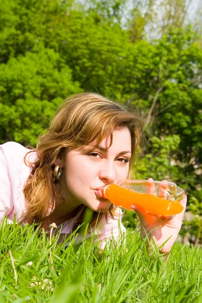 Ładna kobieta, picie soku na polanie lato — Zdjęcie stockowe