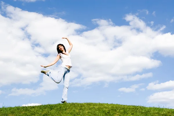Красивая молодая женщина танцует на зеленой траве — стоковое фото