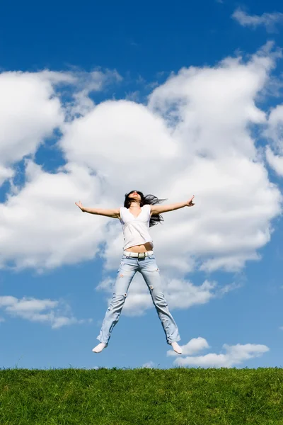 Ganska ung kvinna hoppar på grönt gräs — Stockfoto