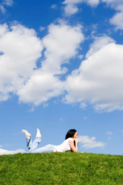 Hübsche Frau ruht sich auf dem grünen Gras aus — Stockfoto