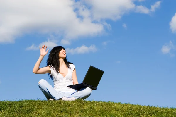 Hübsche Frau mit Laptop im grünen Gras — Stockfoto
