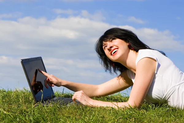 笔记本电脑在绿色草地上的搞笑女人 — 图库照片