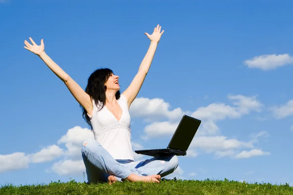 stock image Pretty woman with laptop on the green grass