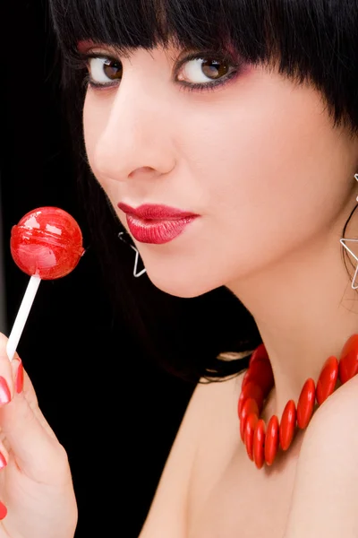 Süße Frau mit Süßigkeiten auf schwarzem Hintergrund — Stockfoto