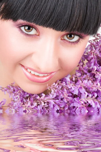 Jonge vrouw met lila bloemen — Stockfoto