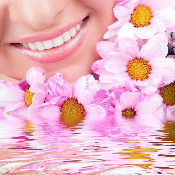 Sonrisa de mujer joven con flores —  Fotos de Stock