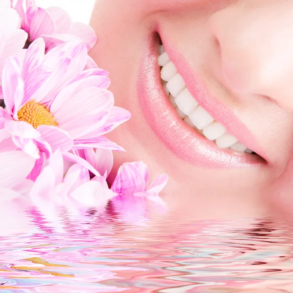 Sorriso di giovane donna con fiori — Foto Stock