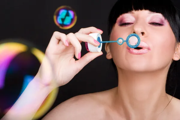 Mladá žena fouká mýdlová bublina — Stock fotografie