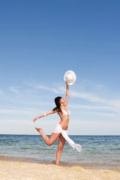 Fröhliche junge Frau tanzt am Strand — Stockfoto