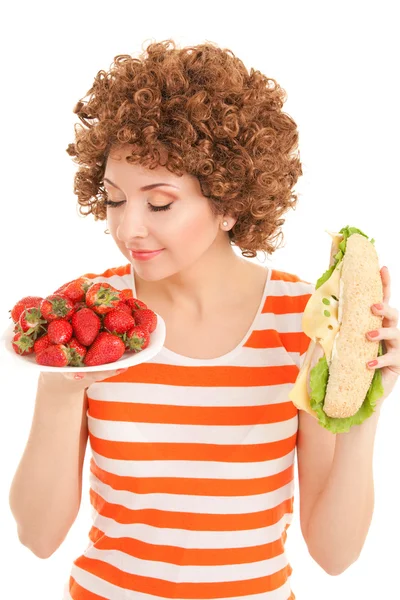 Femme amusante avec fraise et sandwich sur le fond blanc — Photo