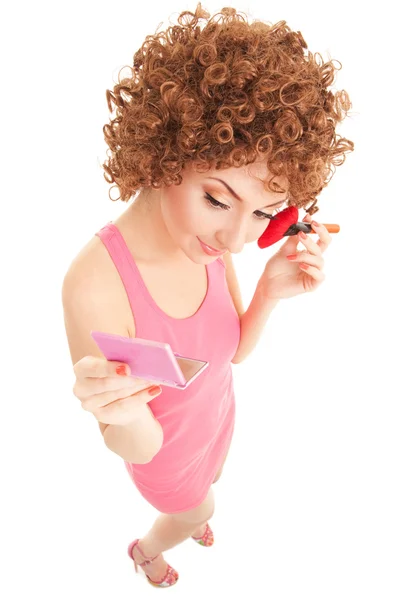 Mujer divertida con cepillo para maquillaje en el fondo blanco — Foto de Stock