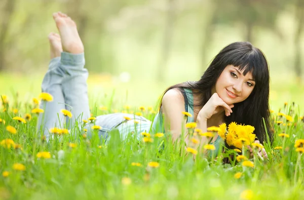 Young woman in the park with flowers — Stock Photo, Image