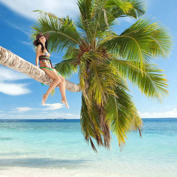 Kobieta moda usytuowanie na palmę na plaży — Zdjęcie stockowe