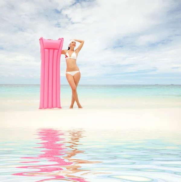 Счастливая женщина с надувным матрасом на пляже — стоковое фото