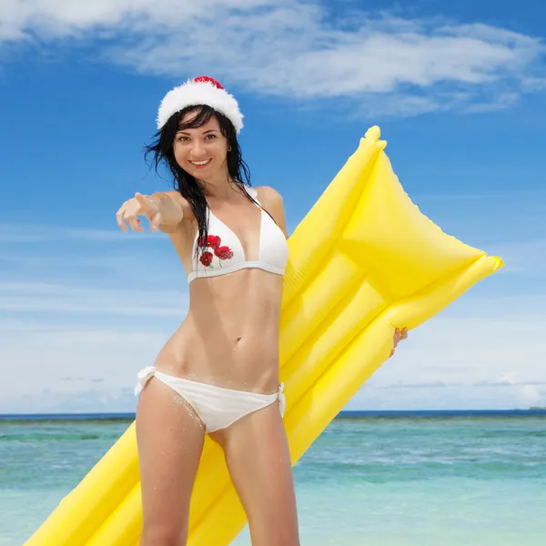 Счастливый Санта женщина с надувной матрас на пляже — стоковое фото