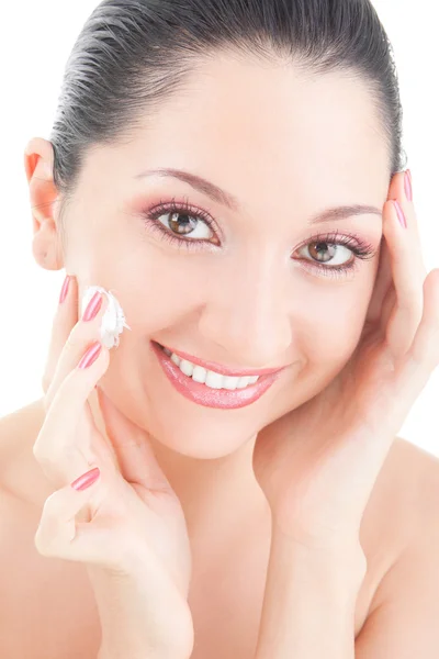 Vrouw crème op haar gezicht op de witte achtergrond toe te passen — Stockfoto