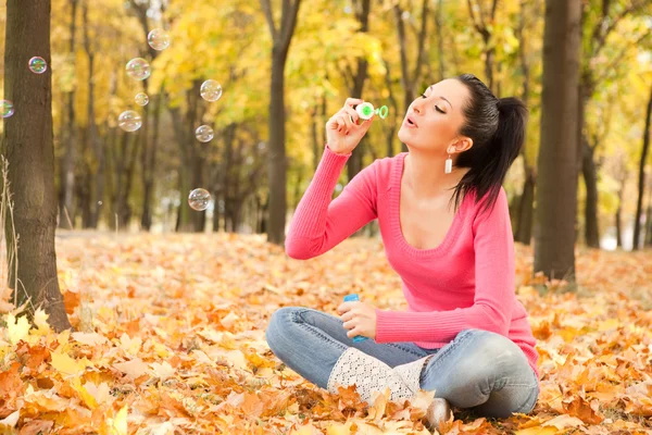 Genç kadın sonbahar parkta sabun köpüğü üfleme — Stok fotoğraf