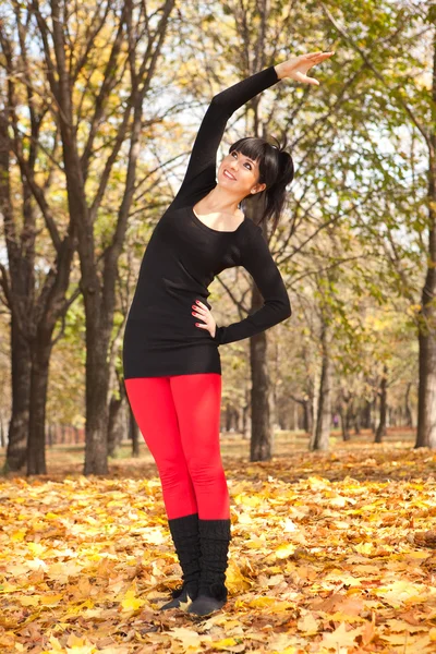 Ładna kobieta robi ćwiczenia jogi w parku jesień — Zdjęcie stockowe