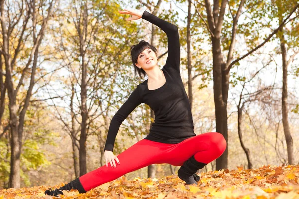 Güzel bir kadın yoga egzersizleri sonbahar Park yapıyor — Stok fotoğraf