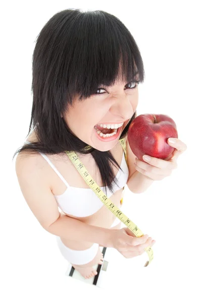 Mujer divertida con manzana roja y cinta métrica en las escamas de vidrio — Foto de Stock