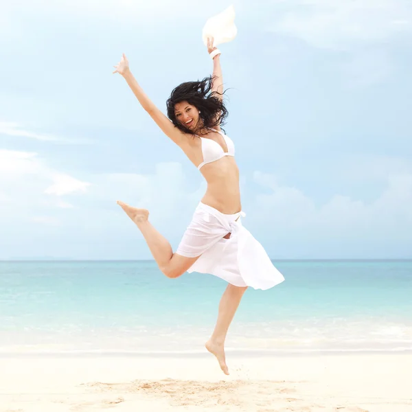 Feliz jovem mulher pulando na praia do mar — Fotografia de Stock