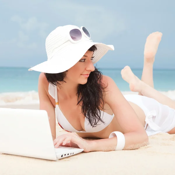 Leuke vrouw met witte laptop op het strand van de zomer — Stockfoto