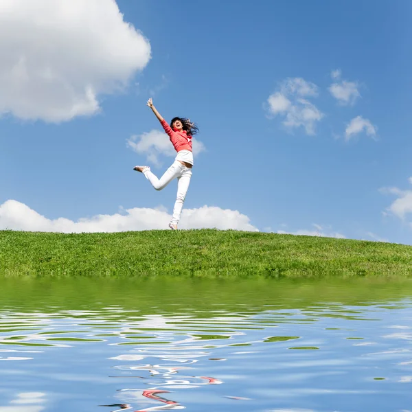 Bardzo młoda kobieta, skoki na zielonej trawie — Zdjęcie stockowe