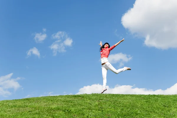 Bella giovane donna che salta su erba verde — Foto Stock