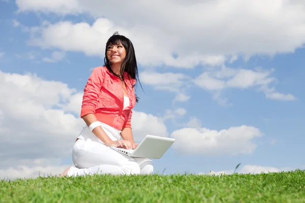 Nette Frau mit weißem Laptop im Park — Stockfoto