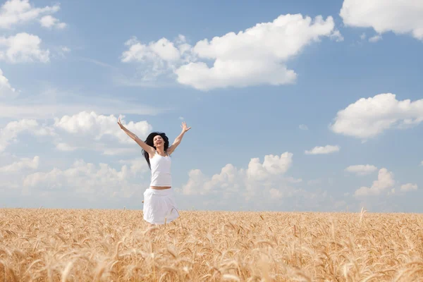 Mujer feliz saltando en trigo dorado —  Fotos de Stock