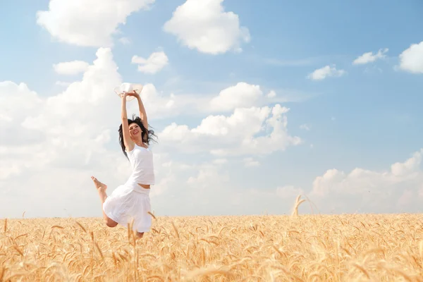 Mulher feliz pulando no trigo dourado — Fotografia de Stock