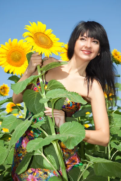 Молодая женщина в поле подсолнухов — стоковое фото