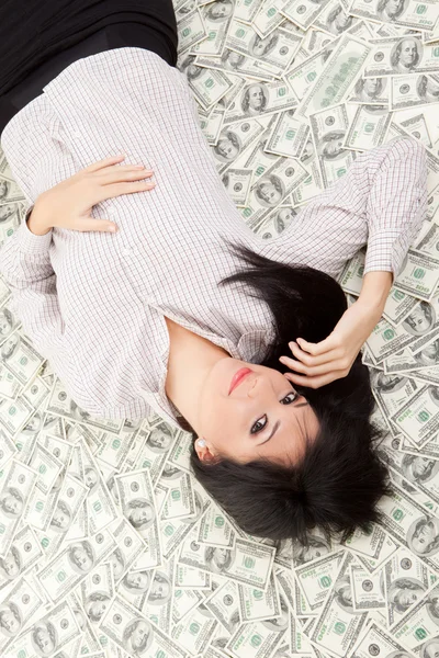 Jovem mulher de negócios descansando sobre o dinheiro — Fotografia de Stock