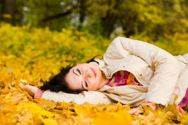 年轻漂亮的妇女休息秋天叶上 — 图库照片