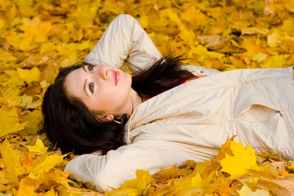 Młode ładne kobiety reszta na jesień liść — Zdjęcie stockowe