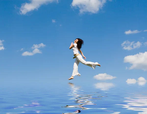 Happy young woman jumping on the water — Stock Photo, Image