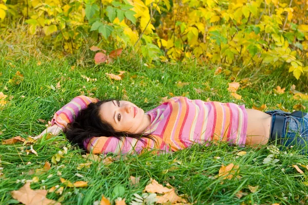 stock image Young pretty woman rest on the autumn grass