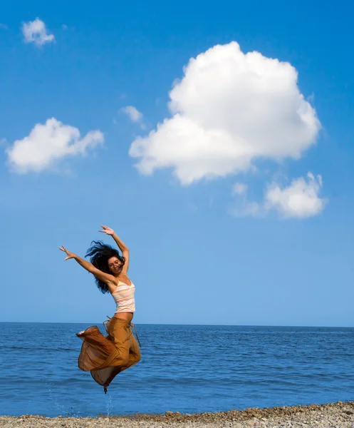 Szczęśliwa młoda kobieta jest skakanie na plaży — Zdjęcie stockowe