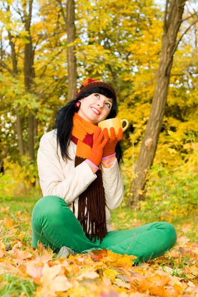 Young pretty woman with cup of tea in the autumn park — Stock Photo, Image