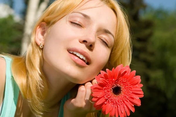Donna riposo nel parco con fiore — Foto Stock