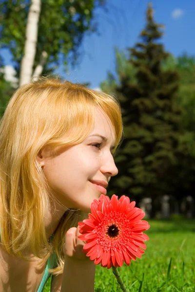 Vacker kvinna resten i parken med blomma — Stockfoto