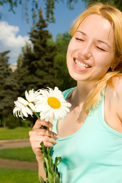 Spaßfrau rastet im Park mit Blumen aus — Stockfoto