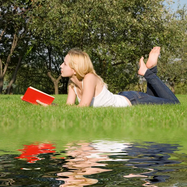 Joven rubia lee libro en el parque —  Fotos de Stock