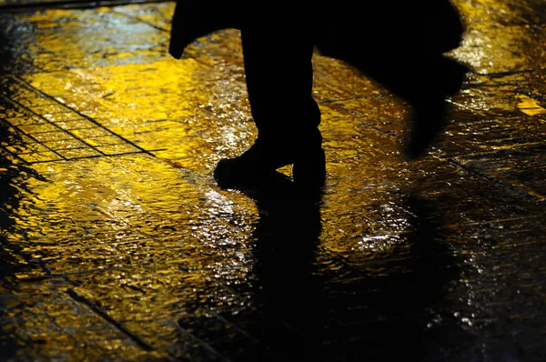 L'uomo che cammina sotto la pioggia Fotografia Stock