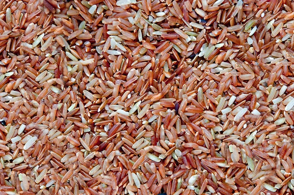 Closeup hnědá rýže neleštěná pozadí textury — Stock fotografie