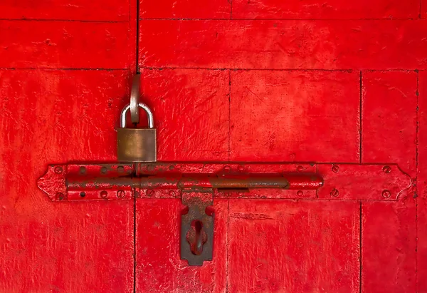 Der Altmeisterschlüssel und der alte Riegel an der roten Holztür — Stockfoto