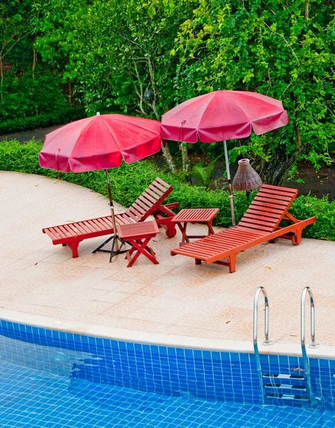 Das Holzbett mit Sonnenschirm am Pool — Stockfoto