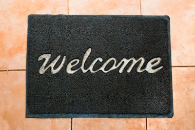 The Doormat of welcome text on wood background clipart